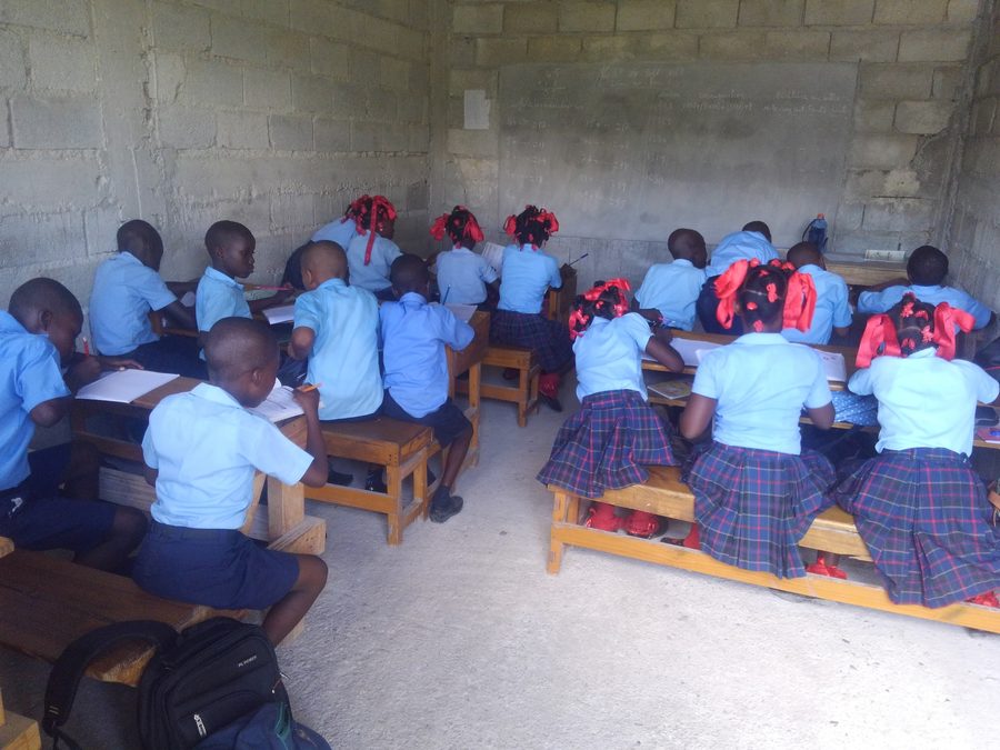 Students working at wooden desks inside a classroom