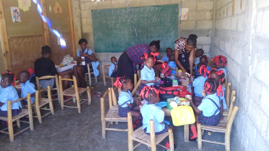 A teacher working with young students at the front of a classroom