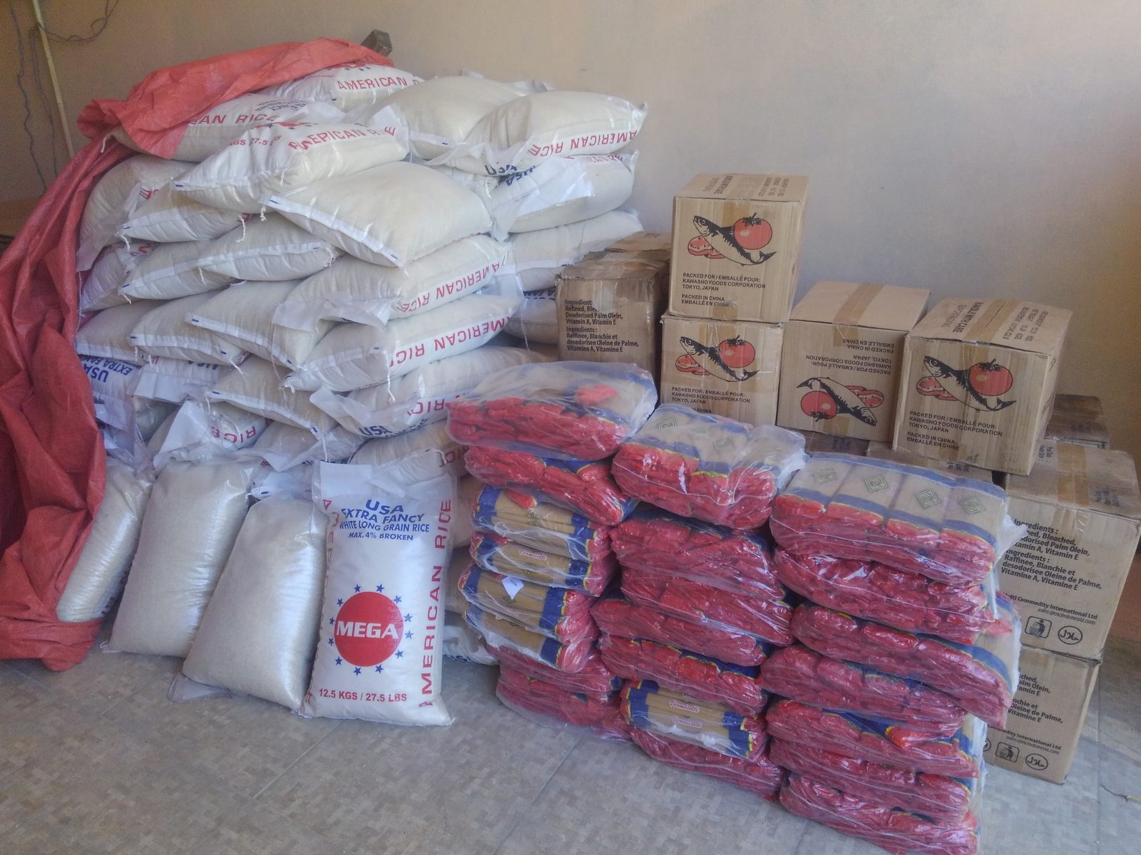 Sacks of rice and boxes of supplies stacked and ready for an LCA distribution